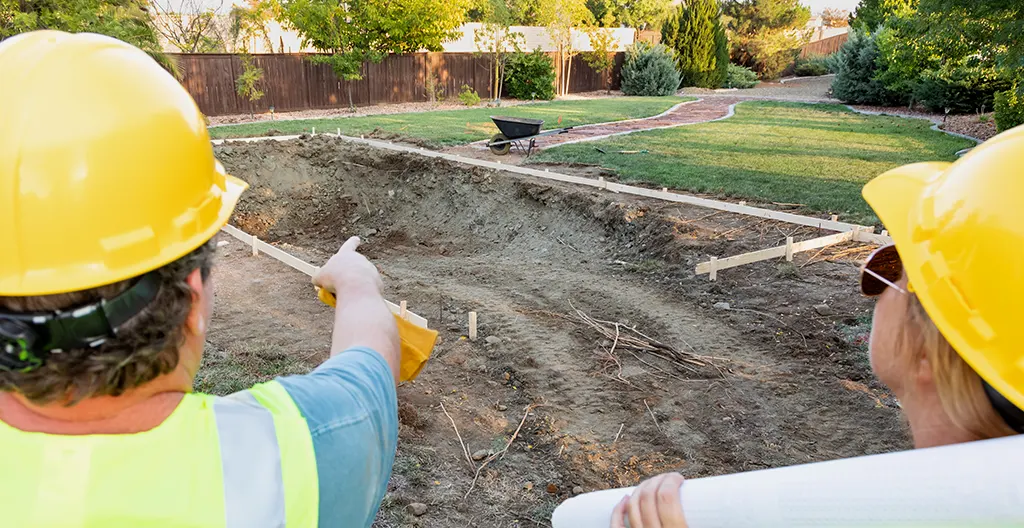 Terrain préparé pour piscine avec marquages de détection réseaux colorés